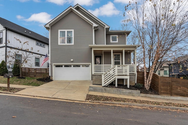 view of front of property featuring a porch, fence, driveway, and an attached garage