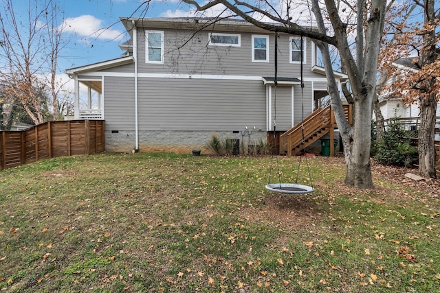 rear view of house with stairs, crawl space, a fenced backyard, and a lawn