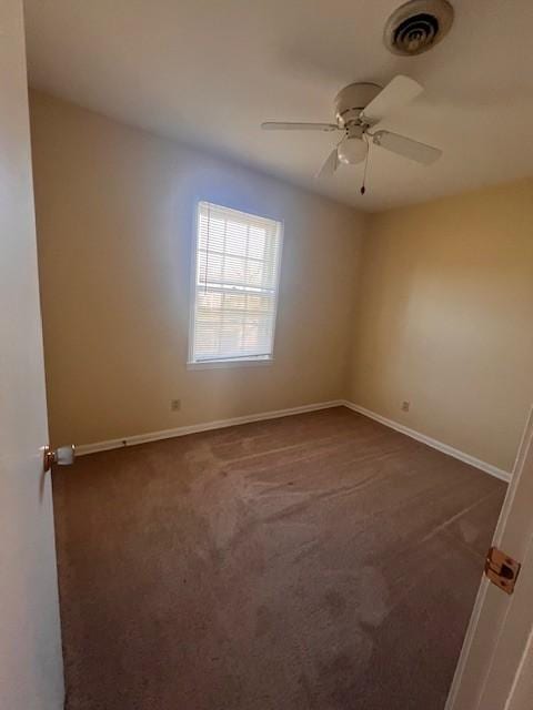 unfurnished room featuring dark carpet and ceiling fan