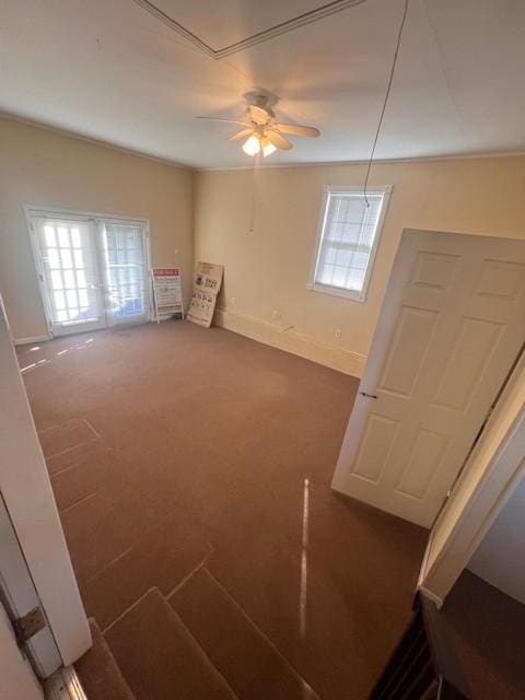 carpeted spare room featuring crown molding, plenty of natural light, and ceiling fan