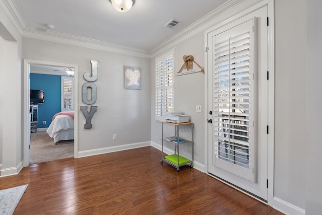 entrance foyer featuring crown molding, a healthy amount of sunlight, and dark hardwood / wood-style floors