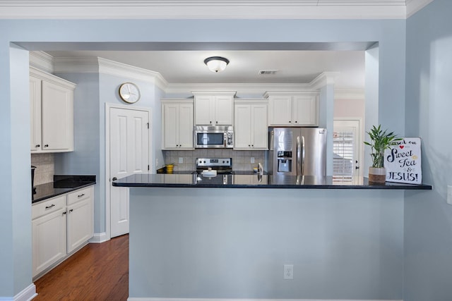 kitchen featuring white cabinetry, appliances with stainless steel finishes, backsplash, and kitchen peninsula