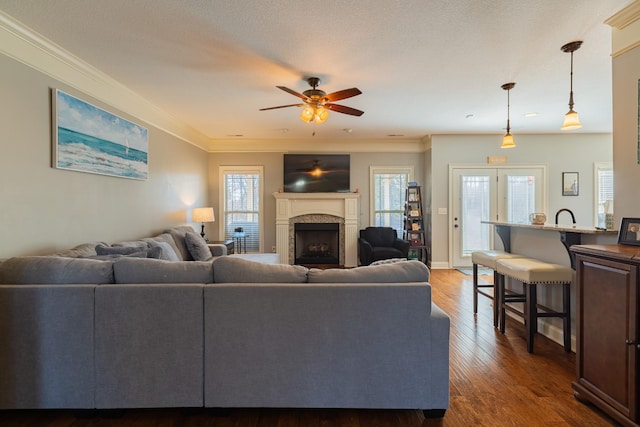 living room with ornamental molding, a textured ceiling, ceiling fan, and dark hardwood / wood-style flooring