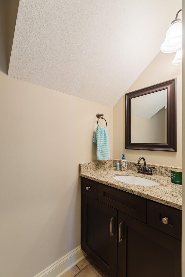 bathroom with vanity, tile patterned flooring, and vaulted ceiling