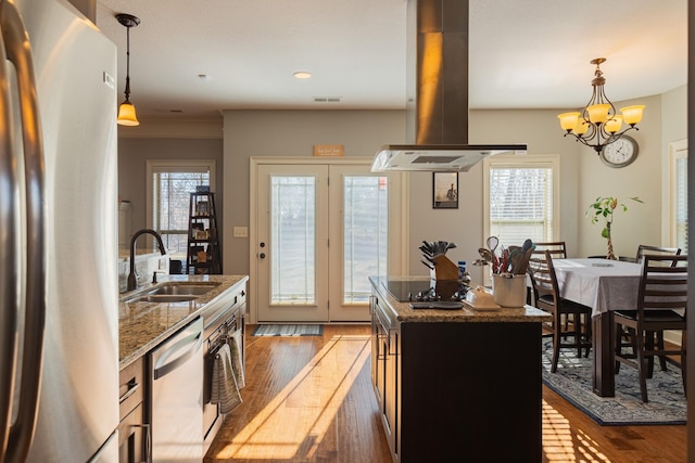 kitchen with sink, dark stone countertops, appliances with stainless steel finishes, a kitchen island, and island exhaust hood