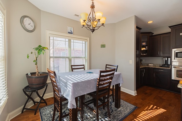 dining area with a notable chandelier and dark wood-type flooring