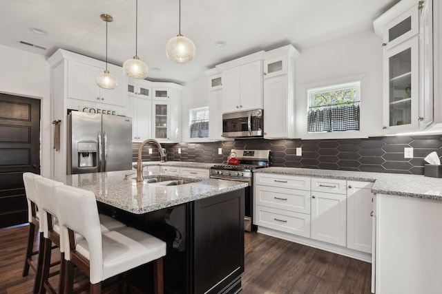 kitchen featuring stainless steel appliances, white cabinetry, sink, and tasteful backsplash