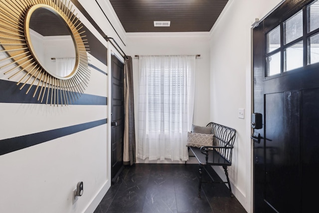 foyer entrance featuring ornamental molding and a barn door