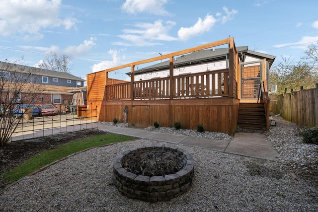 rear view of house featuring a wooden deck and an outdoor fire pit