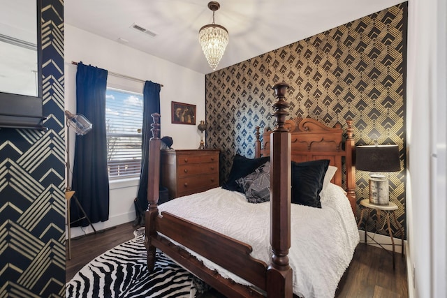 bedroom with dark wood-type flooring and a chandelier