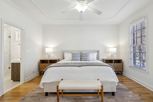 bedroom with ensuite bath, ornamental molding, light hardwood / wood-style floors, and ceiling fan