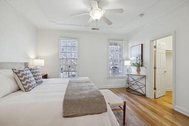 bedroom featuring wood-type flooring, ornamental molding, and ceiling fan