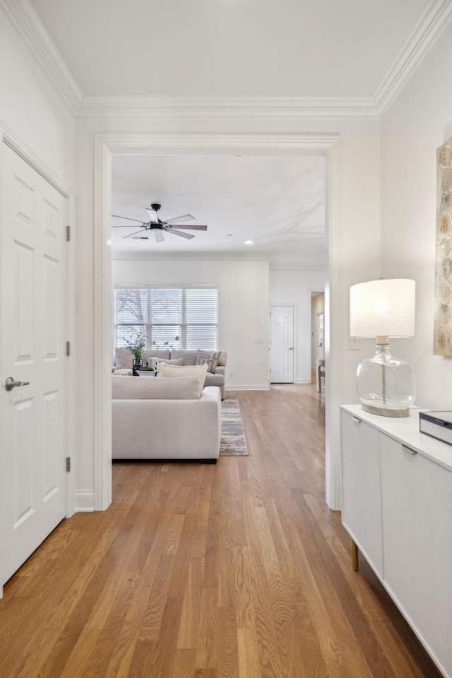 living room featuring ornamental molding, light hardwood / wood-style floors, and ceiling fan