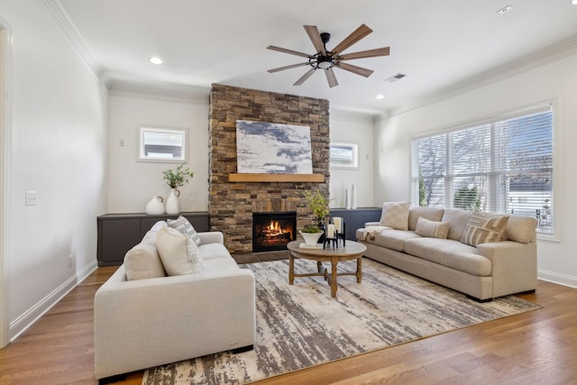 living room with hardwood / wood-style floors, a fireplace, ornamental molding, and ceiling fan