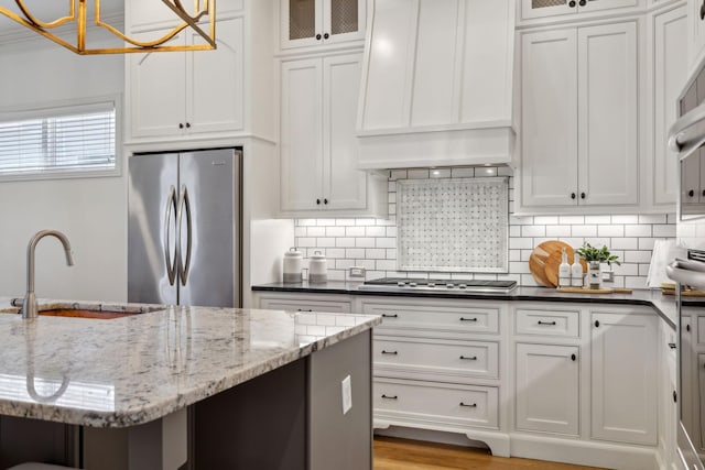 kitchen featuring premium range hood, appliances with stainless steel finishes, sink, and white cabinets