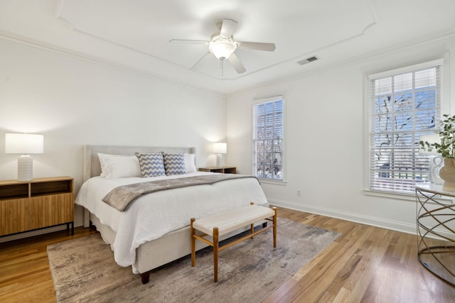 bedroom with wood-type flooring, crown molding, and ceiling fan