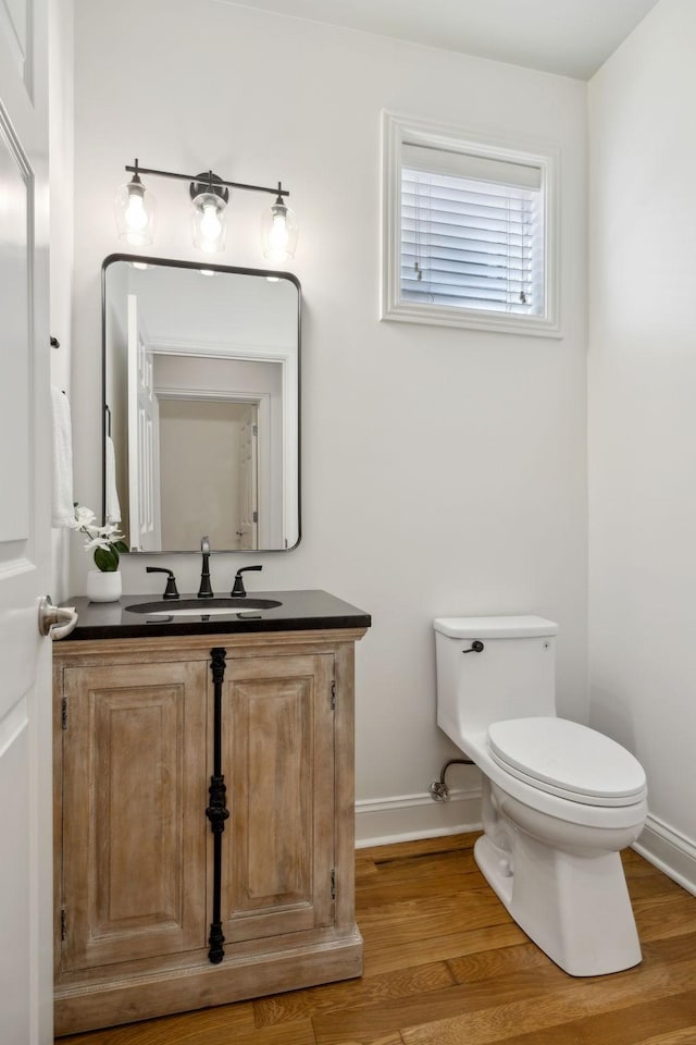 bathroom featuring vanity, wood-type flooring, and toilet