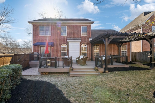 back of property featuring a wooden deck, a pergola, and a lawn