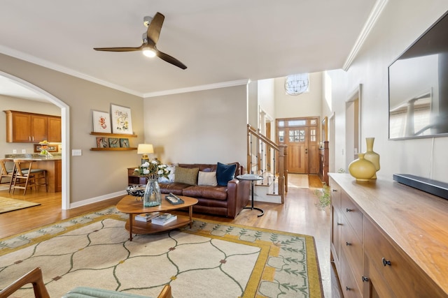 living room featuring ornamental molding, ceiling fan, and light wood-type flooring