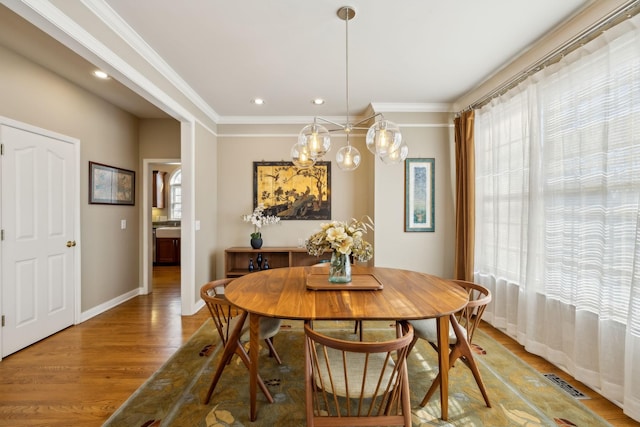 dining space featuring a wealth of natural light, ornamental molding, and hardwood / wood-style floors