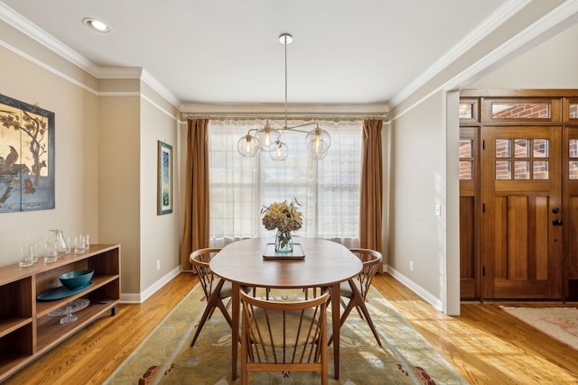 dining room featuring crown molding and light hardwood / wood-style floors