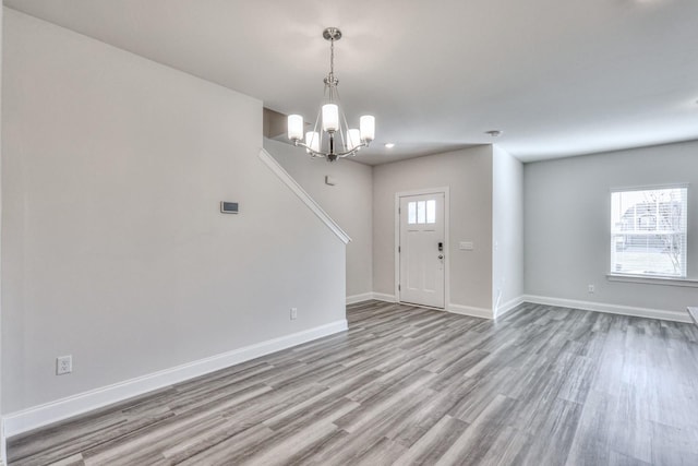 foyer featuring a healthy amount of sunlight, a chandelier, and light wood-type flooring