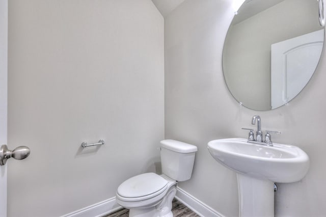 bathroom with hardwood / wood-style flooring and toilet