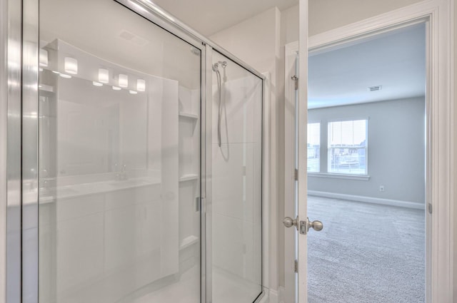 bathroom with a shower with door