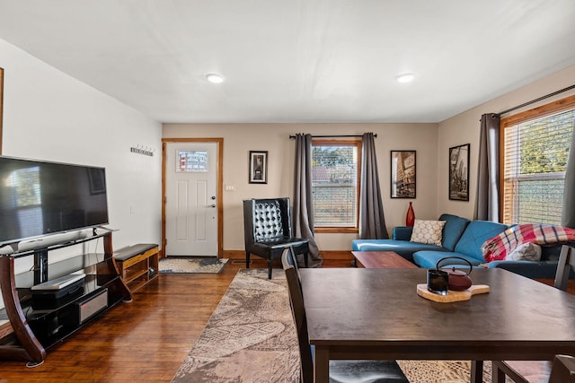 living room featuring a wealth of natural light and dark wood-type flooring