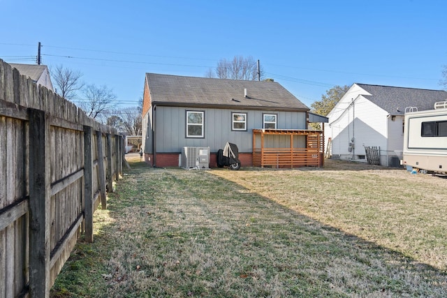 back of house with a lawn and central air condition unit