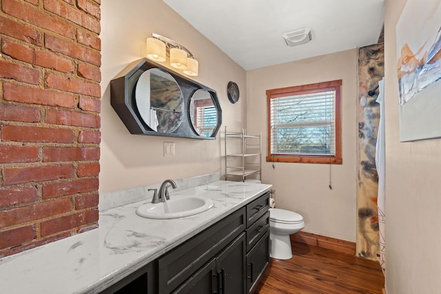 bathroom with wood-type flooring, vanity, and toilet