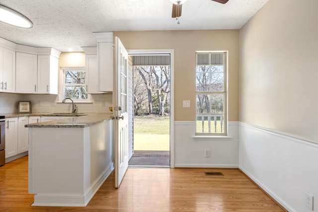 doorway featuring a healthy amount of sunlight, sink, and a textured ceiling