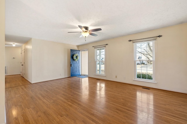 spare room featuring ceiling fan, a textured ceiling, and light wood-type flooring