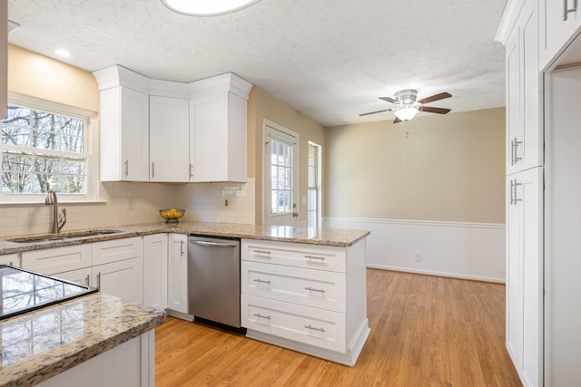 kitchen featuring white cabinetry, dishwasher, and sink