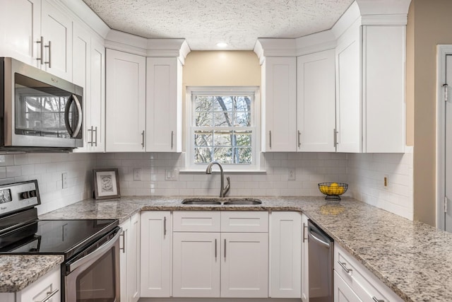 kitchen featuring appliances with stainless steel finishes, sink, and white cabinets