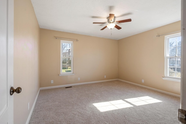 unfurnished room with light colored carpet and ceiling fan