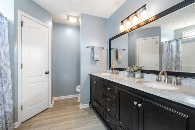 bathroom with vanity, hardwood / wood-style floors, a textured ceiling, and toilet