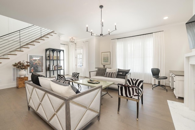 living room with crown molding, plenty of natural light, a chandelier, and hardwood / wood-style floors