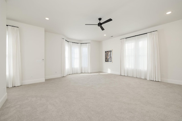 spare room featuring light carpet and ceiling fan