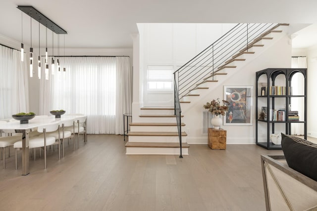 stairway featuring hardwood / wood-style flooring and ornamental molding