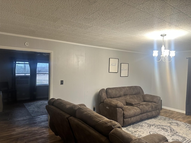 living room with ornamental molding, an inviting chandelier, and dark hardwood / wood-style flooring