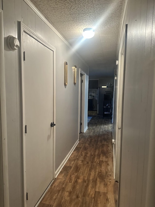 corridor with ornamental molding and dark hardwood / wood-style floors