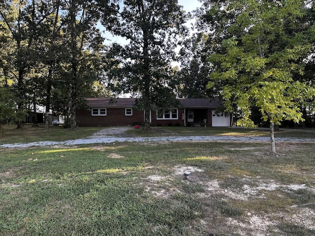 ranch-style house featuring a garage and a front lawn