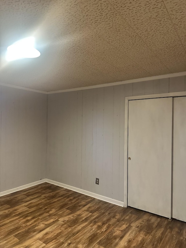 bonus room featuring dark wood-type flooring and wooden walls