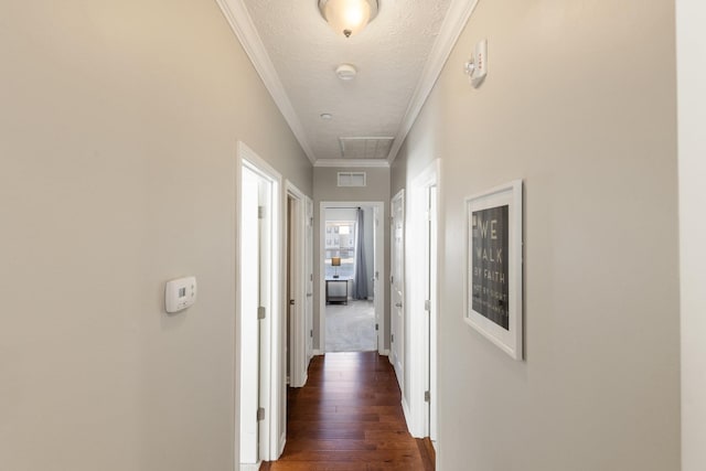 hallway featuring dark wood-type flooring, ornamental molding, and a textured ceiling