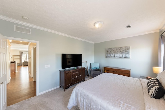 bedroom with crown molding, light colored carpet, and a textured ceiling