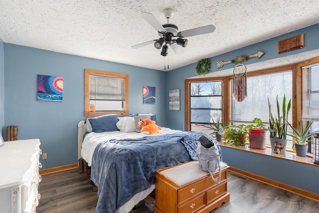 bedroom featuring dark hardwood / wood-style flooring, a textured ceiling, and ceiling fan