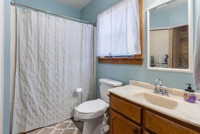 bathroom with vanity, a textured ceiling, and toilet