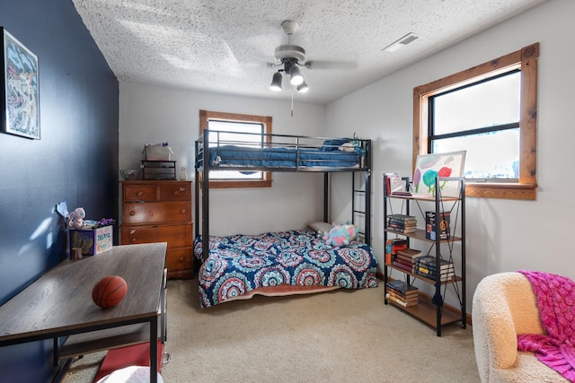 bedroom featuring a textured ceiling, carpet floors, and ceiling fan