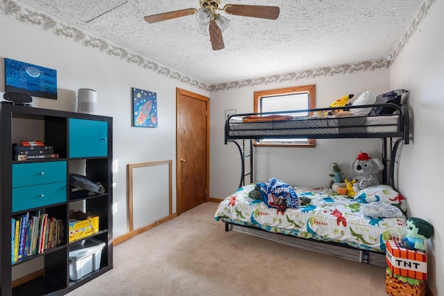 carpeted bedroom featuring a textured ceiling and ceiling fan